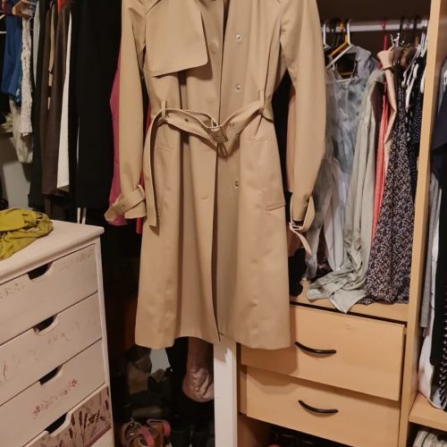 por IA +7 El abrigo que se muestra en la imagen es un trench coat o gabardina, un estilo clásico y atemporal. Este tipo de abrigo se caracteriza por: Diseño: Doble botonadura, cinturón, solapas anchas y, a menudo, detalles como trabillas en los hombros y puños. Material: Tradicionalmente confeccionado en gabardina de algodón resistente al agua, aunque también se puede encontrar en otros materiales como cuero o mezclas sintéticas. Longitud: Generalmente llega hasta la rodilla o un poco más abajo. Estilo: Versátil, puede ser tanto casual como formal, dependiendo de cómo se combine. Es una prenda icónica de marcas como Burberry. Color: Los colores más comunes son el beige, el caqui y el negro, aunque también se pueden encontrar en otros tonos. Marca: La etiqueta en el cuello del abrigo dice "DESIDERATA". Características adicionales: Este abrigo en particular parece tener un cinturón con hebilla y un diseño clásico con detalles como las solapas y los botones en la parte delantera. En resumen, el abrigo de la imagen es un trench coat clásico, similar al modelo "Sandridge" de Burberry. Es una prenda elegante y funcional que se ha mantenido popular a lo largo del tiempo.